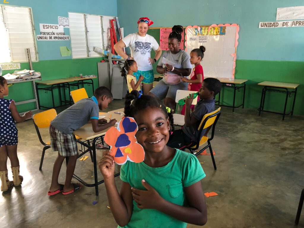 A child in a classroom shares her work.