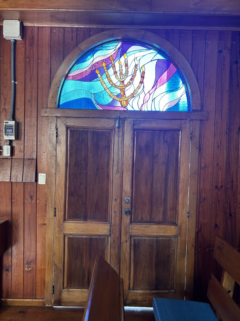A wooden door with bright stained glass above it.