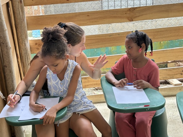 Female teen talks with children.